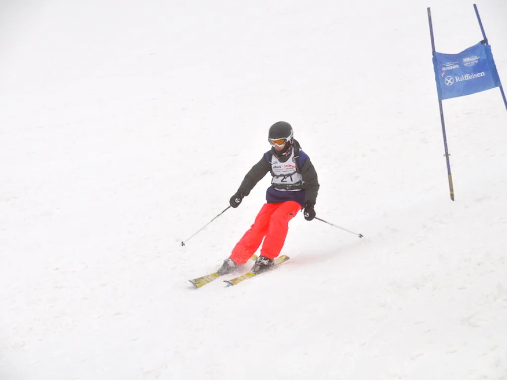 Skifahrer in roter Hose auf der Rennstrecke.